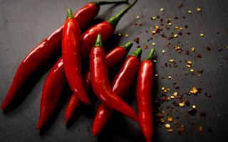 Red peppers spices black surface - scattered free wallpaper