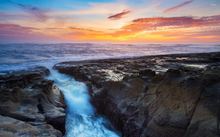 Sunset rocky beach waterfall ocean - over the water free wallpaper for desktop