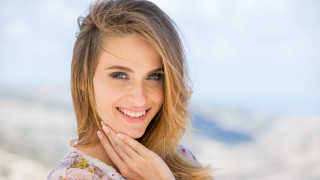 Smiling woman mountain background blonde - her face and a hand free wallpaper