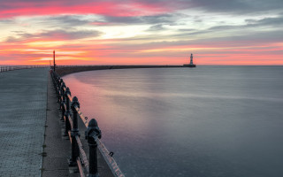 Sunset pier lighthouse water mountains - moody free wallpaper
