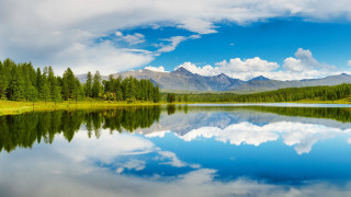 Lake mountains trees clouds water - tree and mountains under a cloudy sky free wallpaper