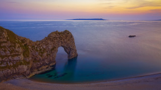 Large rock formation lake mountain - a small island in the distance free wallpaper