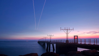 Pier plane sunset contrails water - long exposure free wallpaper
