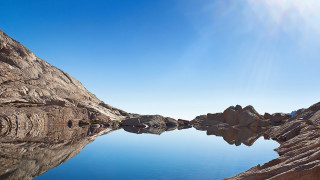 Mountain lake rockface clear sky - a clear blue sky above free wallpaper