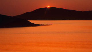 Sunset mountain water boat light - a mountain in the background and a boat free wallpaper
