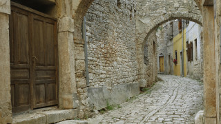 Narrow cobblestone street romanque arch - a brick walkway free wallpaper