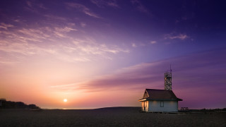 Small white building beach sunset - a sun setting behind free wallpaper