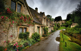 Stone houses flower lined street - a wet road free wallpaper