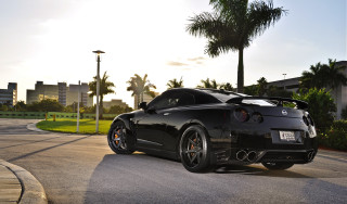Black sports car palm tree 2 - a building in the background free wallpaper