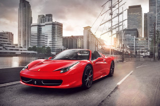 Red sports car cityscape bridge 2 - tall building and a river in the background free wallpaper