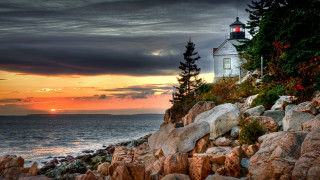 Lighthouse rocky shore sunset clouds 3 - a lighthouse free wallpaper