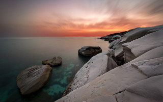 Rocky shore sunset clouds mountains - the water and a sunset in the background free wallpaper