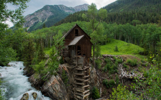 Cliffside wooden house river mountains - free mountains wallpaper