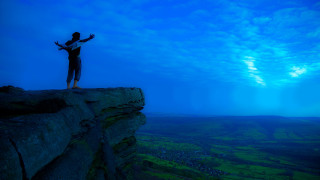 Cliff man outstretched arms valley - top of a cliff free wallpaper