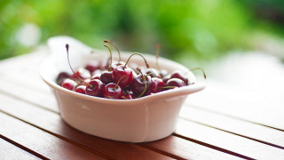 Bowl cherries wooden table sunlight - a wooden table outside free wallpaper