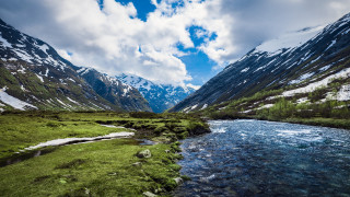 Lush green valley stream mountains 2 - a lush green valley under a cloudy sky free wallpaper