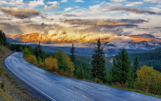 Mountain road clouds trees sky 2 - a mountain in the background free wallpaper