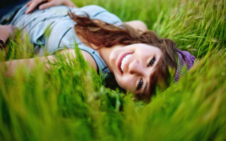Woman smiling grass blowing wind - free summer wallpaper