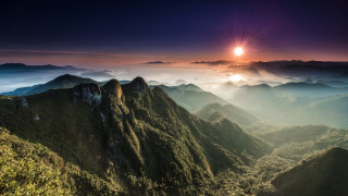 Mountain range sunset clouds lake 3 - a bright sun in the distance free wallpaper