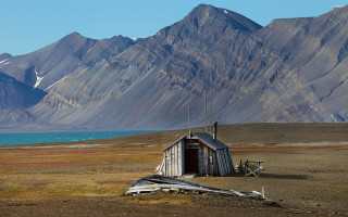 Small shack field mountains lake - the background and a lake in the foreground free wallpaper