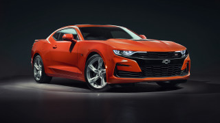 Bright orange chevrolet camaro studio - a black background and a spotlight free wallpaper