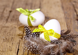 Eggs bows feathers wooden table - a green ribbon free wallpaper