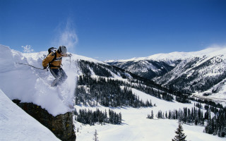 Man skier jumping cliff mountains - ski free wallpaper
