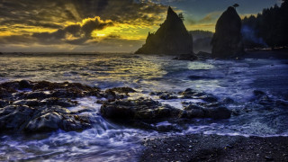 Sunset rocky beach waves mountains - a rock formation in the foreground free wallpaper