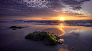 Sunset beach rock water mountain - a sunset over a beach free wallpaper