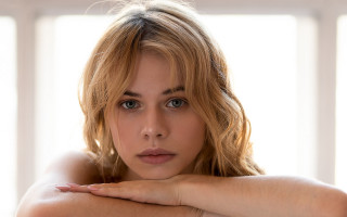 Serious blonde blue eyed portrait - her face and shoulder free wallpaper