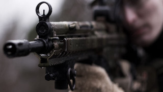 Man aiming gun blurry background - cinematic focus free wallpaper
