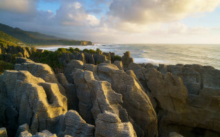 Rocky cliff beach cloudy sky - free mountains wallpaper