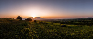 Grassy hill sunset rocks trees - free sunset wallpaper