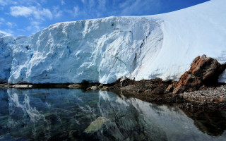 Iceberg reflection lake rock shore - a large iceberg free wallpaper