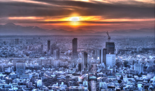 Cityscape sunset mountains cloudy sky - a bright sun free wallpaper