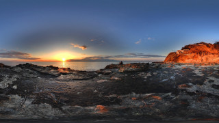 Sunset rocks water mountains city - a large rock free wallpaper