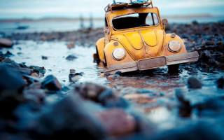 Yellow car beach water surfboard - tilt shift free wallpaper