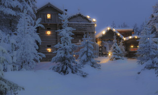 Snowy cabin trees lights night - free christmas wallpaper