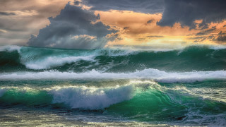 Large wave ocean cloudy sky - a sunbeam in the distance free wallpaper