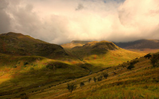 Grassy field mountains cloudy sky - dramatic light free wallpaper for desktop