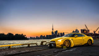 Yellow sports car waterfront city - the side of a road near a body of water free wallpaper