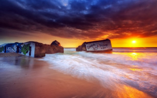 Sunset beach rock graffiti cinematic - a sunset over a beach free wallpaper
