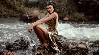 Gold dress woman river rocks - a forest in the background free wallpaper