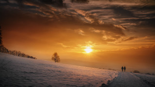 Snowy path dusk cityscape lighthouse - the sun setting behind them free wallpaper