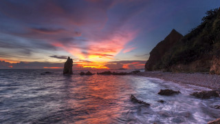 Sunset rocky beach bridge city - a sunset over a rocky beach free wallpaper