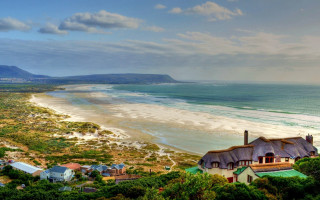 Beach thatched roof white sand - a blue sky and ocean in the background free wallpaper