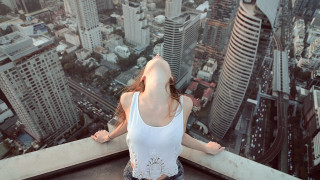Woman cityscape ledge outstretched arms - a ledge in front free wallpaper