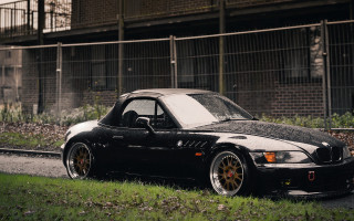 Black car road building fence - a black car free wallpaper