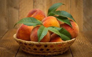 Basket peaches leaves wooden table - a wooden wall free wallpaper
