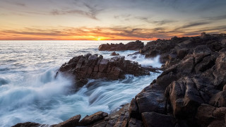 Rocky shore waves sunset cloudscape - against the rock free wallpaper